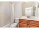 This bathroom features wood cabinets and a shower with a white curtain at 430 Easy Wind Ln, Garner, NC 27529