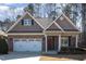 Attractive brick home with dormer windows, landscaped yard, and a red front door adorned with a wreath at 430 Easy Wind Ln, Garner, NC 27529
