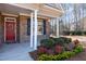 Inviting front porch with white columns, brick facade, and colorful landscaping with flowers and shrubbery at 430 Easy Wind Ln, Garner, NC 27529