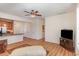 Open-concept living area with hardwood floors, ceiling fan, and a view into an adjacent kitchen at 430 Easy Wind Ln, Garner, NC 27529
