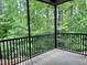 Relaxing screened porch with black railings offers serene views of lush green trees at 430 Easy Wind Ln, Garner, NC 27529