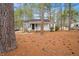 Charming front exterior featuring a cozy front porch, complemented by lush trees at 432 Fowlkes St, Wendell, NC 27591