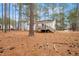 Rear exterior view, highlighting a back deck with stairs and wooded backyard with lush pine trees at 432 Fowlkes St, Wendell, NC 27591