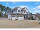 Exterior of a two story house featuring a basketball hoop, stone garage and white siding at 4913 Sunset Stream Dr, Fuquay Varina, NC 27526