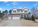Charming two-story home featuring a stone and white siding, complemented by a well-manicured lawn at 4913 Sunset Stream Dr, Fuquay Varina, NC 27526