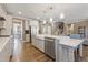 Bright, modern kitchen features white cabinets, stainless steel appliances, and a large island with seating at 4913 Sunset Stream Dr, Fuquay Varina, NC 27526