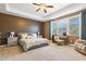 Spacious main bedroom boasts a tray ceiling, a ceiling fan and a seating area at 4913 Sunset Stream Dr, Fuquay Varina, NC 27526