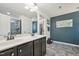Bathroom featuring a double sink vanity with a large mirror, tiled floors, and blue accent wall at 505 Ferry Ct, Wake Forest, NC 27587