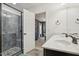 Bathroom with a gray tile shower, glass door, double vanity, and a view into an adjacent bedroom at 505 Ferry Ct, Wake Forest, NC 27587
