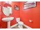 Powder room with a pedestal sink, toilet, and vibrant red walls at 505 Ferry Ct, Wake Forest, NC 27587