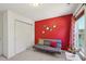 Spare bedroom with a futon, closet, red accent wall, and a patterned window curtain at 505 Ferry Ct, Wake Forest, NC 27587