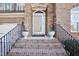 Charming home front entrance with brick steps, iron railings, and decorative potted plants at 508 Spencer Crest Ct, Cary, NC 27513