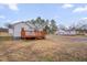 This backyard has a spacious yard, driveway, and a red wooden deck at 516 Craven Road, Durham, NC 27704