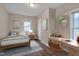 Comfortable bedroom with a bed, a desk, wood floors, and a calm atmosphere at 516 Craven Road, Durham, NC 27704