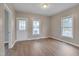 Inviting room with hardwood floors, neutral walls, and door access to front porch at 516 Craven Road, Durham, NC 27704
