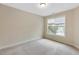 Well-lit bedroom with neutral walls, plush carpet, and a window providing natural light at 627 Balsam Fir Dr, Cary, NC 27519
