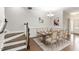 Formal dining room with wood table set for six, chandelier, and hardwood floors next to staircase at 627 Balsam Fir Dr, Cary, NC 27519