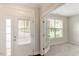 Bright entryway with white door, transom window, and sidelight leading to an open room with neutral carpeting at 627 Balsam Fir Dr, Cary, NC 27519