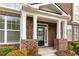 Inviting front porch with classic columns, brick accents, and a well-maintained garden at 627 Balsam Fir Dr, Cary, NC 27519