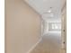 Carpeted hallway with neutral walls and bright lighting provides access to additional rooms at 627 Balsam Fir Dr, Cary, NC 27519