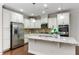 A gourmet kitchen featuring stainless steel appliances, granite countertops, and custom white cabinetry at 627 Balsam Fir Dr, Cary, NC 27519