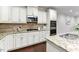 Close up of the chef's kitchen showcasing granite counters, stainless appliances and custom backsplash at 627 Balsam Fir Dr, Cary, NC 27519
