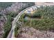 An aerial view of the community with a pond surrounded by trees and winding roads at 664 The Parks Dr, Pittsboro, NC 27312