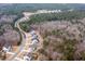 A picturesque aerial view showcases the neighborhood's home sites bordering a lush forest and a pond nearby at 664 The Parks Dr, Pittsboro, NC 27312