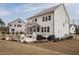 Expansive backyard with a stone patio, fire pit, outdoor seating, and a covered porch at 664 The Parks Dr, Pittsboro, NC 27312