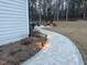 Stone paver walkway with lights leads to a backyard patio with lounge chairs and a fire pit at 664 The Parks Dr, Pittsboro, NC 27312