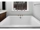 A large and luxurious bathtub is centered in front of a bright window at 664 The Parks Dr, Pittsboro, NC 27312