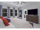 Bedroom with multiple windows, ceiling fan, ensuite bathroom and large dresser with TV at 664 The Parks Dr, Pittsboro, NC 27312