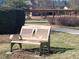 Park bench with a tree on it, offers a peaceful spot to relax, within a landscape of walkways and vegetation at 664 The Parks Dr, Pittsboro, NC 27312