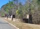 Stone community entrance and fence line highlighting the neighborhood's manicured landscaping and peaceful atmosphere at 664 The Parks Dr, Pittsboro, NC 27312