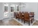 The dining room has a modern light fixture, a view of the outdoor patio, and space for ten at 664 The Parks Dr, Pittsboro, NC 27312
