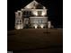 Two-story home illuminated at night, highlighting the stone accents and manicured lawn at 664 The Parks Dr, Pittsboro, NC 27312