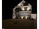Beautifully illuminated two-story home at night with stone accents and manicured landscaping at 664 The Parks Dr, Pittsboro, NC 27312