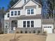 Beautiful two-story home with stone accents, bright windows, a well-kept lawn, and attached garage at 664 The Parks Dr, Pittsboro, NC 27312