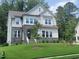 Charming two-story home with stone accents, white siding, and a lush green lawn at 664 The Parks Dr, Pittsboro, NC 27312