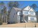 Two-story home with stone accents, multiple windows, and a well-maintained lawn at 664 The Parks Dr, Pittsboro, NC 27312