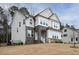 Elegant two-story home with a stone and siding exterior, a manicured lawn and landscaping at 664 The Parks Dr, Pittsboro, NC 27312