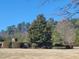 The landscape showcases a variety of trees and neatly trimmed hedges, complemented by a well-manicured lawn at 664 The Parks Dr, Pittsboro, NC 27312