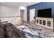 Upstairs living room with a comfortable leather couch, blue accent wall, and modern decor at 664 The Parks Dr, Pittsboro, NC 27312
