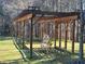 Pergola with metal butterfly bench amidst nature, creates a serene and inviting outdoor seating space at 664 The Parks Dr, Pittsboro, NC 27312
