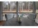 A screened-in porch featuring a table with seating overlooking a wooded area, perfect for relaxation at 664 The Parks Dr, Pittsboro, NC 27312