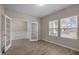 Bright bedroom featuring wood floors, two windows and glass paneled doors at 721 Sage Oak Ln, Holly Springs, NC 27540