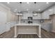 Bright modern kitchen with a center island, stainless appliances, and eye-catching herringbone tile backsplash at 721 Sage Oak Ln, Holly Springs, NC 27540