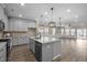 Spacious, open kitchen with island, modern lighting, and stainless steel appliances at 721 Sage Oak Ln, Holly Springs, NC 27540