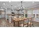Bright eat-in kitchen with stainless appliances, gray cabinetry and a stylish light fixture above the table at 721 Sage Oak Ln, Holly Springs, NC 27540