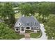 Aerial view of home on lush lot, with manicured lawn, mature trees, and nearby golf course and lake at 7217 Manor Oaks Dr, Raleigh, NC 27615
